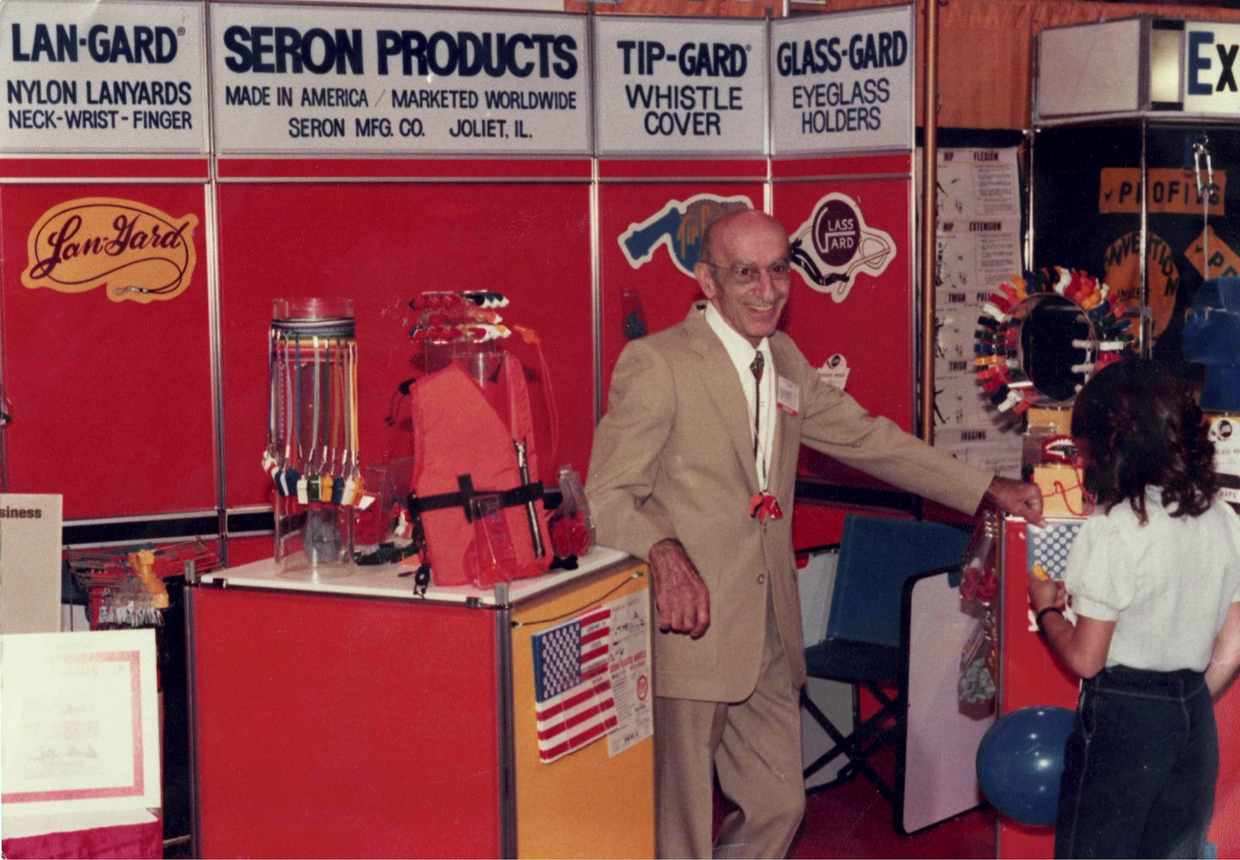 Dr. Suren M. Seron standing at the Seron Products exhibit during the 1976 NSGA trade show